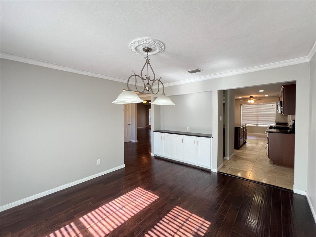 6151 Alpha Road Dallas, TX 75240 - Photo 16 of 39 a view of a hallway with wooden floor and a chandelier