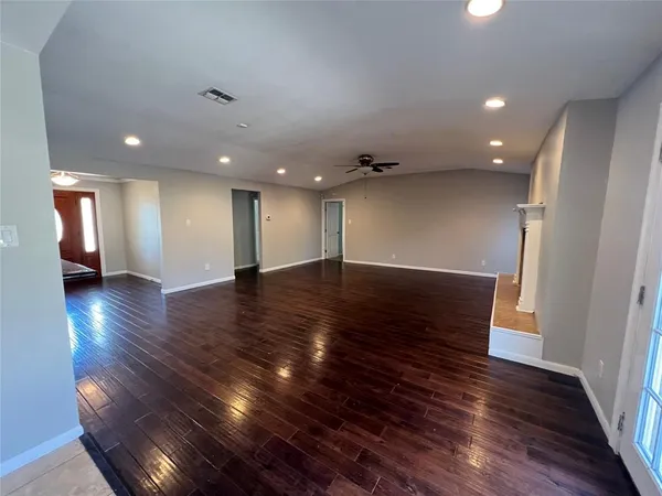 a view of an empty room with wooden floor
