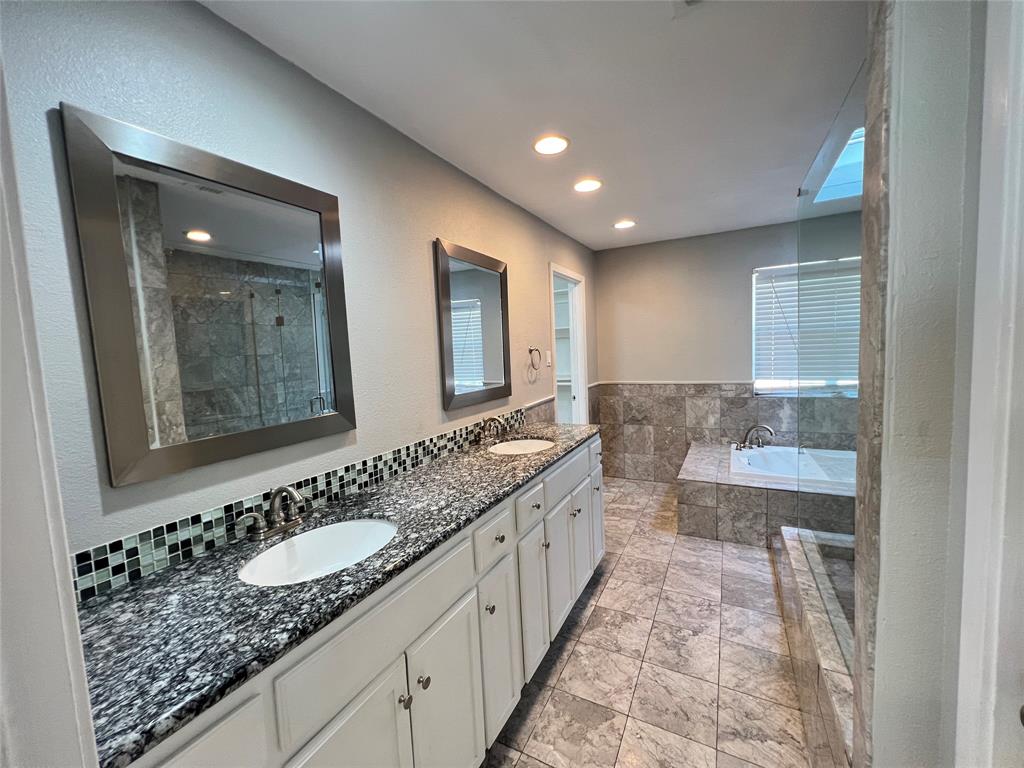 6151 Alpha Road Dallas, TX 75240 - Photo 32 of 39 a bathroom with double vanity sinks and a bathtub