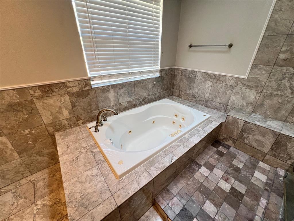 6151 Alpha Road Dallas, TX 75240 - Photo 34 of 39 a bath tub sitting in a bathroom next to a sink