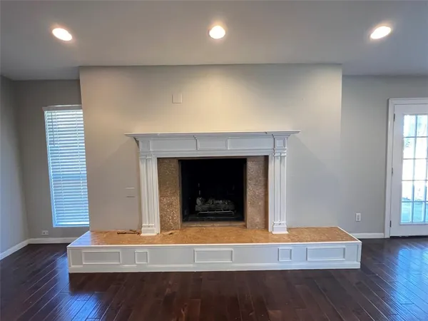 an empty room with wooden floor and a fireplace