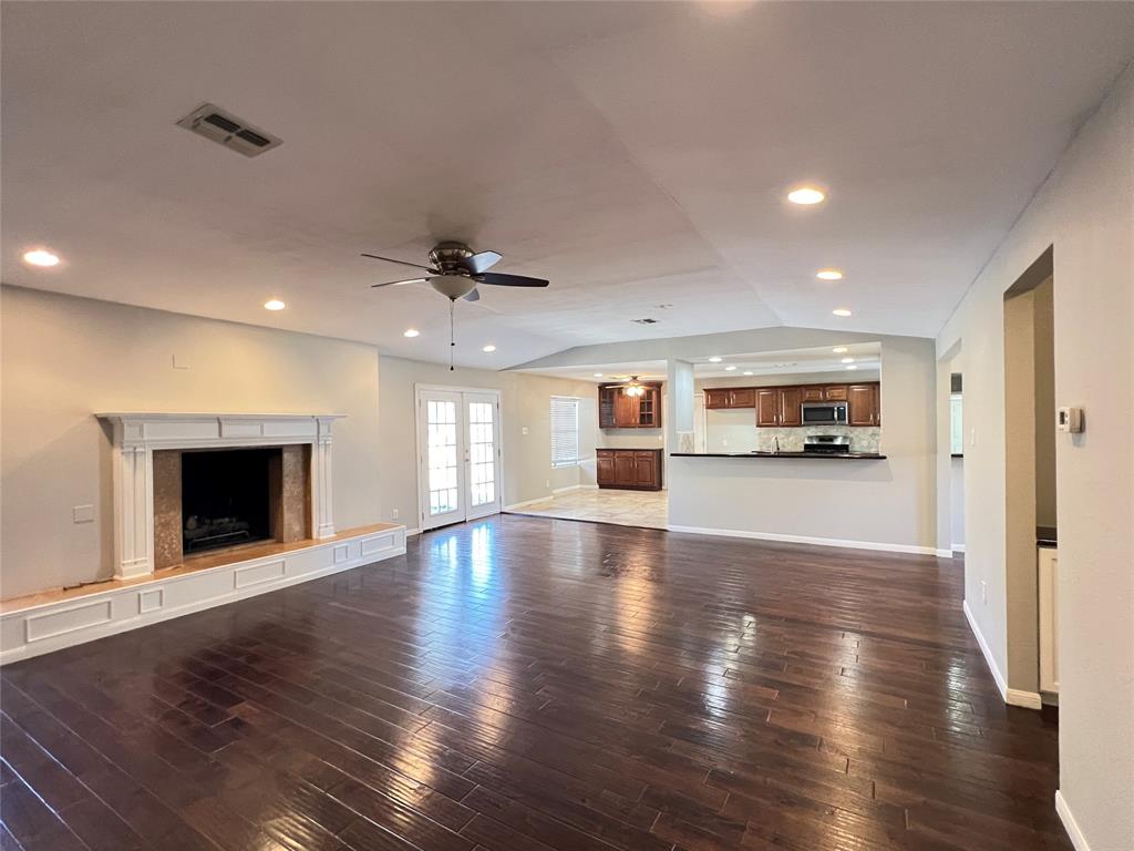 6151 Alpha Road Dallas, TX 75240 - Photo 7 of 39 a view of an empty room with wooden floor and a kitchen