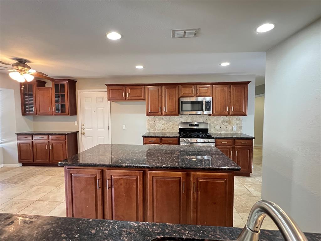 6151 Alpha Road Dallas, TX 75240 - Photo 8 of 39 a kitchen with stainless steel appliances granite countertop a sink stove and refrigerator