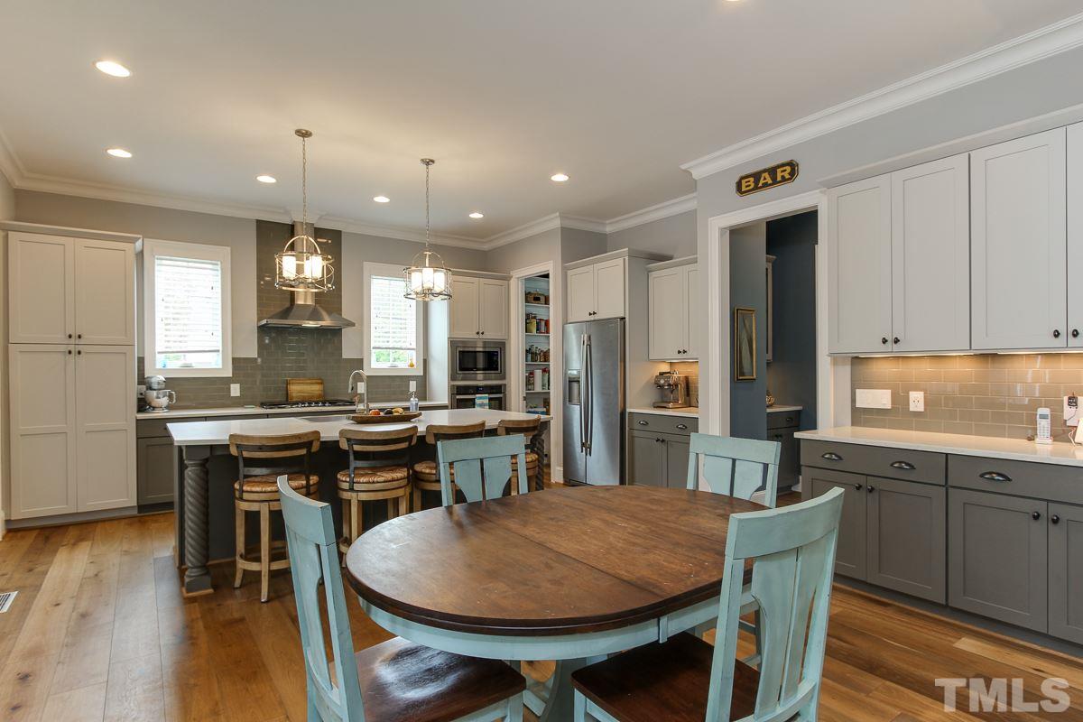 2315 Bedford Avenue Raleigh, NC 27607 - Photo 9 of 25 a kitchen with stainless steel appliances granite countertop a stove a sink a refrigerator dining table and chairs