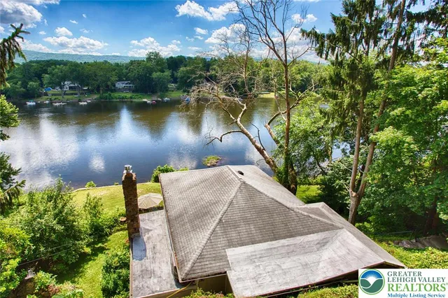 an aerial view of a house with pool and lake view