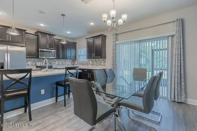 a dining room with furniture a chandelier and wooden floor
