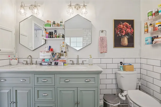 a bathroom with a toilet sink and mirror