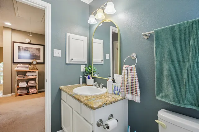 a bathroom with a granite countertop sink and a mirror