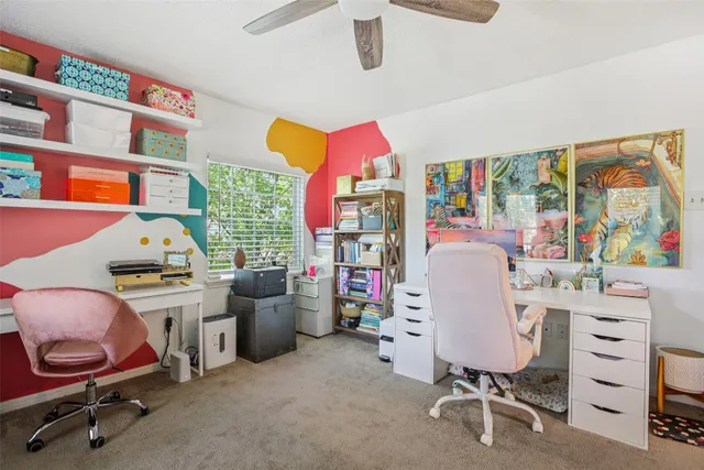 a view of a workspace with furniture and a window