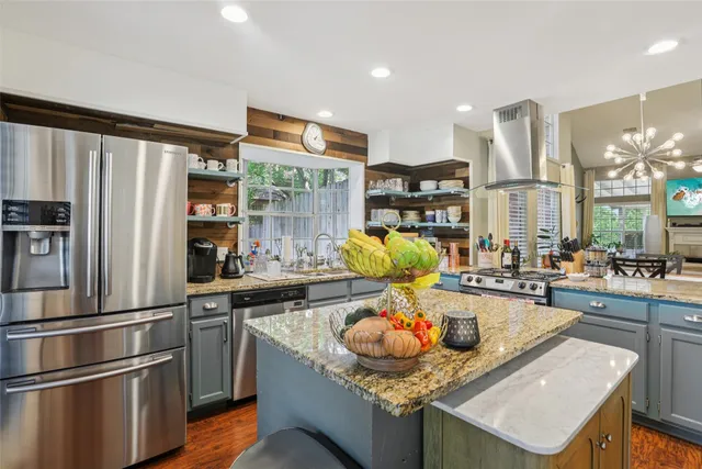 a kitchen with stainless steel appliances granite countertop a sink refrigerator and cabinets