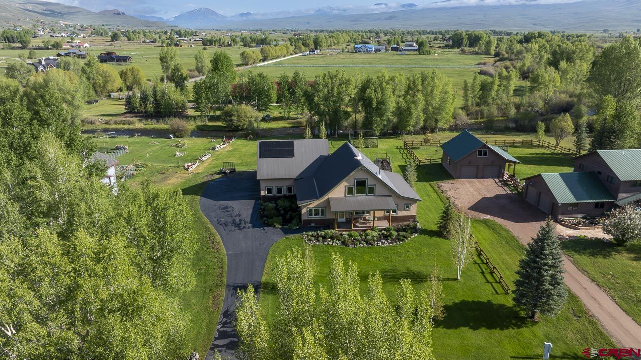 157 Spring Meadow Trail Gunnison, CO 81230 - Photo 3 of 43 Park-like grounds, mature trees, vegetable garden, raspberry/strawberry garden, paved asphalt driveway, borders Ohio Creek. 7 minutes North of Gunnison. Custom with quality materials and workmanship.