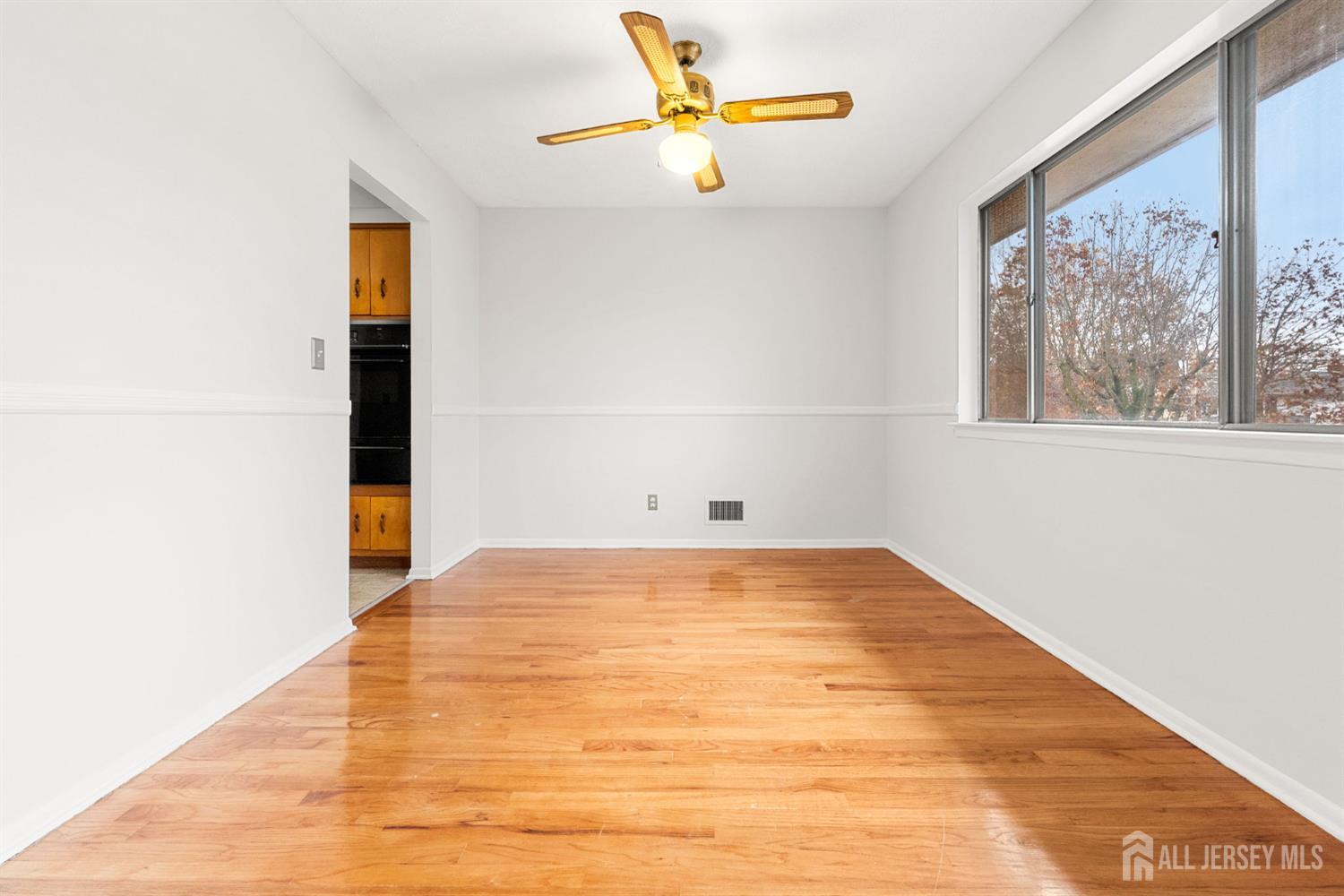 89 Van Buren Avenue, Unit 2 Metuchen, NJ 08840 - Photo 8 of 16 a view of empty room with wooden floor and fan