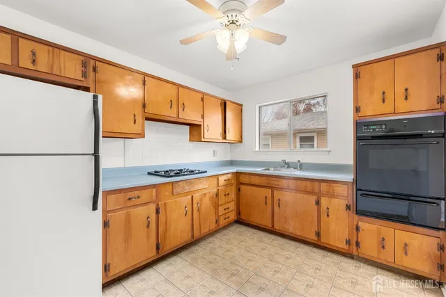 a kitchen with stainless steel appliances granite countertop a sink and a refrigerator