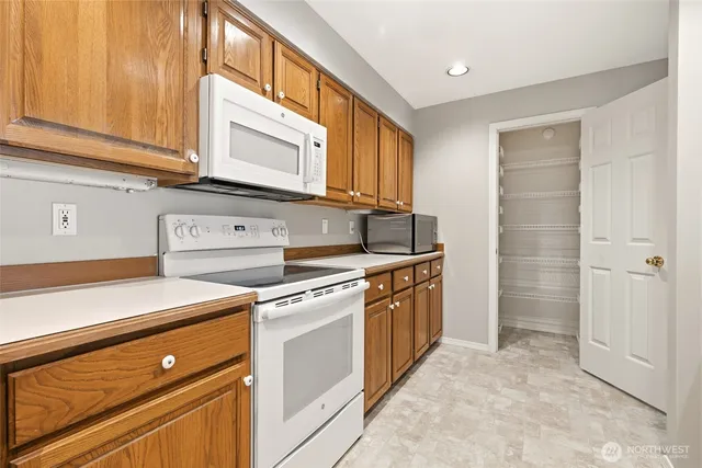 a kitchen with stainless steel appliances granite countertop a stove a sink and a microwave