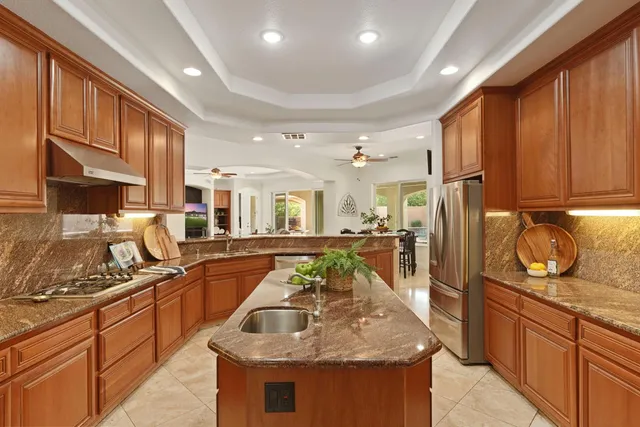 a bed sitting in a spacious bedroom next to a window and a dresser