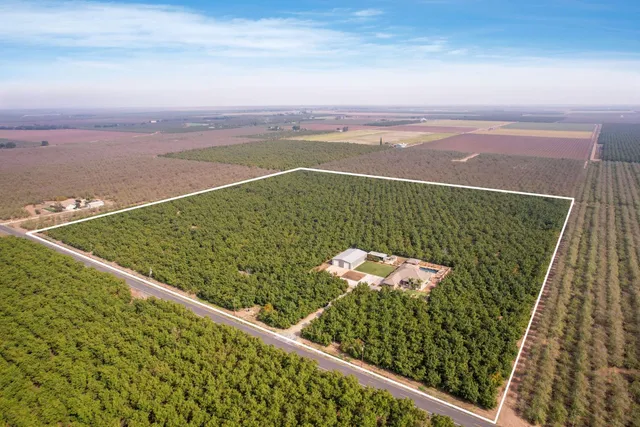 an aerial view of a house with a yard swimming pool and outdoor seating