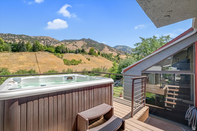 510 Spring Creek Road Providence, UT 84332 - Photo 29 of 97 Outdoor deck featuring a built-in hot tub, cable railing, and a sloped roofline