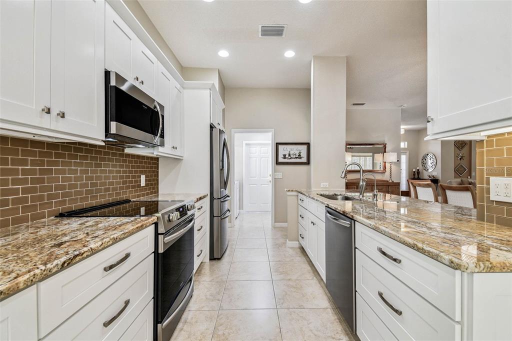 12202 Aaron Terrace Trinity, FL 34655 - Photo 15 of 41 a kitchen with stainless steel appliances granite countertop a stove top oven a sink dishwasher a refrigerator and a oven