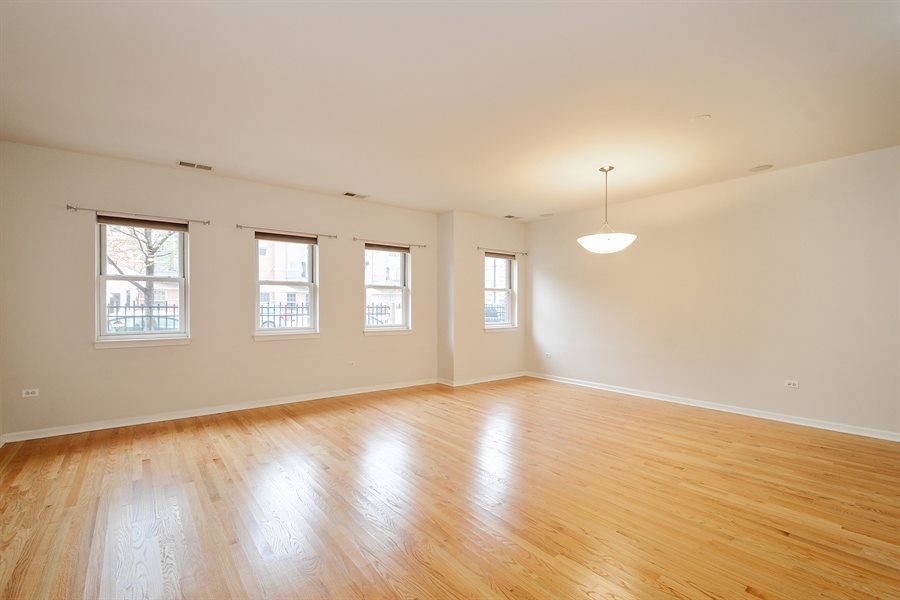 1421 South Halsted Street, Unit 1A Chicago, IL 60607 - Photo 3 of 15 an empty room with wooden floor and windows