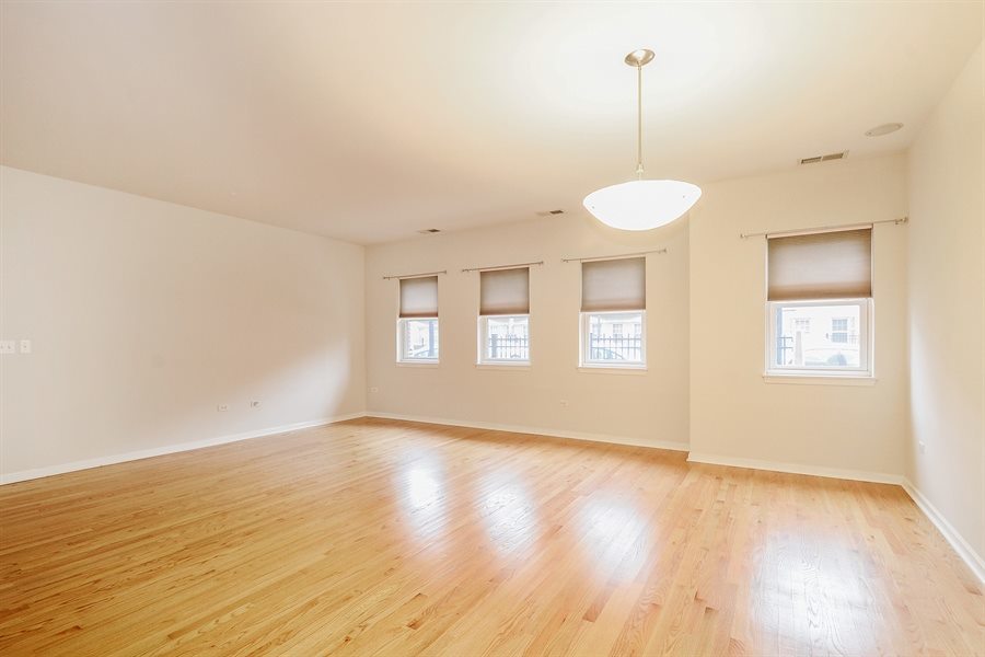 1421 South Halsted Street, Unit 1A Chicago, IL 60607 - Photo 4 of 15 a view of an empty room with wooden floor and a window