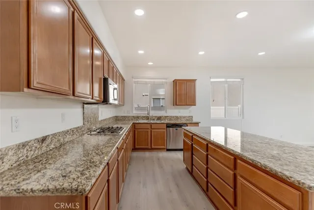 a kitchen with granite countertop sink stainless steel appliances and cabinets