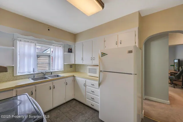 a kitchen with a refrigerator and cabinets