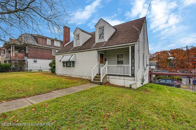 a view of a house with a yard and sitting area