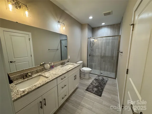 a bathroom with a double vanity sink toilet and shower