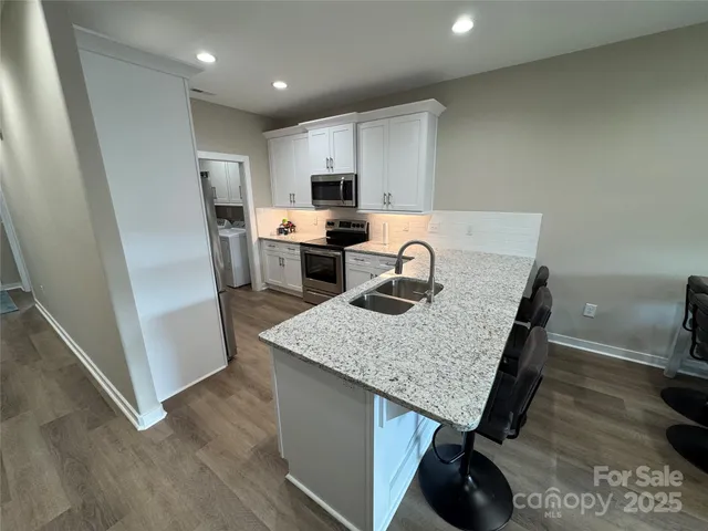 a kitchen with a sink a microwave a refrigerator and cabinets