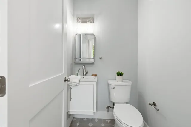 a bathroom with a sink a toilet and a mirror