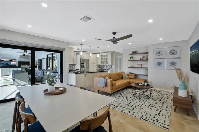 a living room with furniture kitchen view and large windows