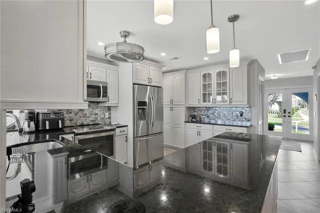 a kitchen with stainless steel appliances granite countertop a stove refrigerator and cabinets