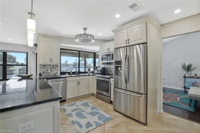 a kitchen with granite countertop stainless steel appliances a sink cabinets and counter space