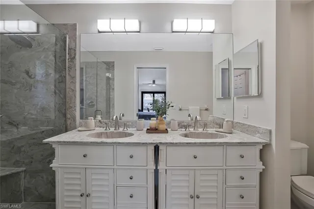 a bathroom with double sink and a mirror