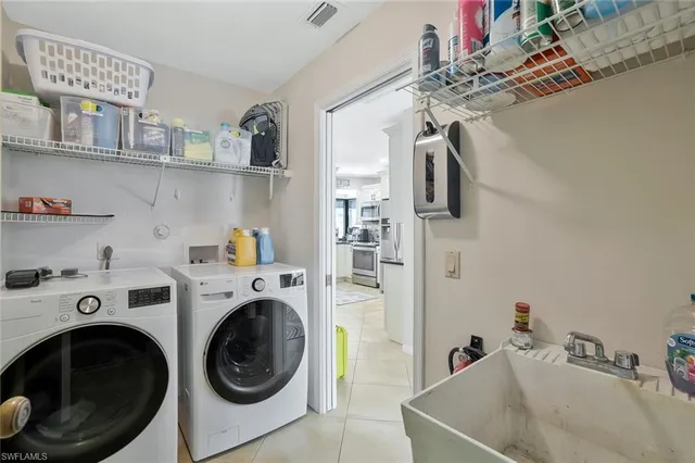a utility room with sink dryer and washer