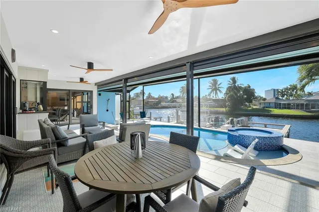 a dining room with furniture a rug and a floor to ceiling window