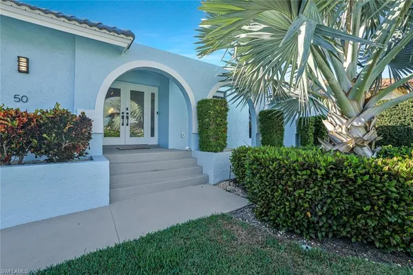 a front view of a house with plants
