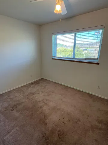 an empty room with wooden floor windows and entrance