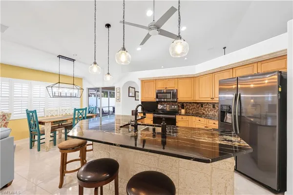 a kitchen with a table chairs stove and wooden floor