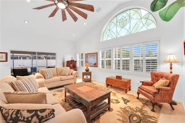a living room with furniture a fireplace and a large window