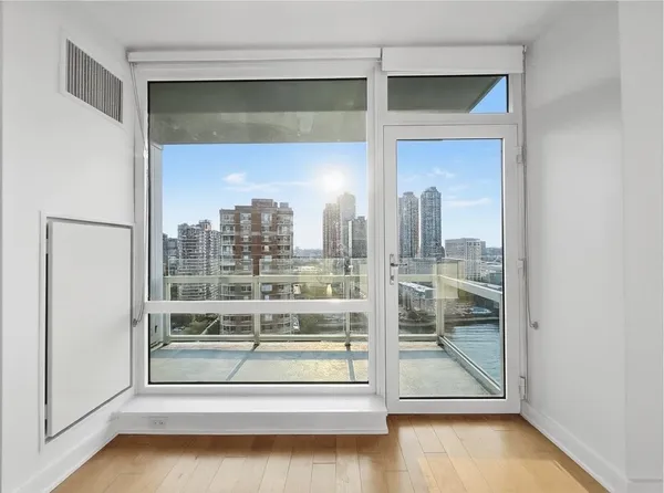 a view of a room with wooden floor and a window