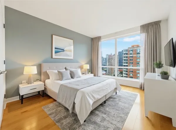 a bedroom with bed and a large window