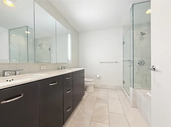 a spacious bathroom with a shower sink and mirror