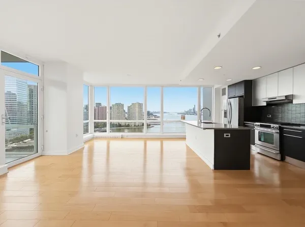 a large white kitchen with a large window and stainless steel appliances