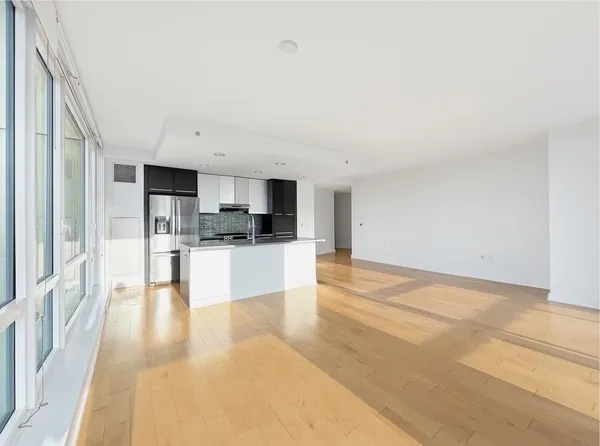 a view of kitchen with kitchen island a sink wooden floor and stainless steel appliances