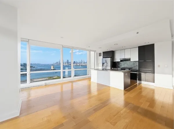 a large kitchen with stainless steel appliances kitchen island granite countertop a large counter top and a view of living room