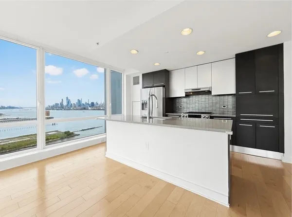 a large kitchen with a large counter top stainless steel appliances and cabinets