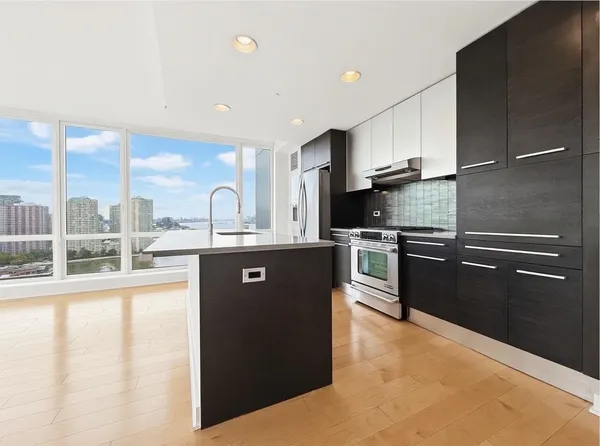 a kitchen with stainless steel appliances granite countertop a sink a stove and a refrigerator