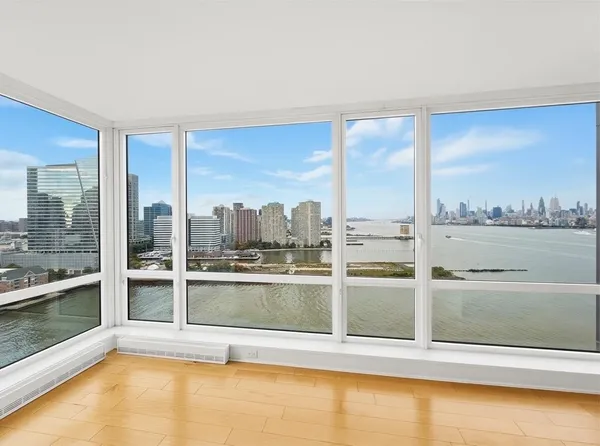 a view of a living room hardwood floor and a large window