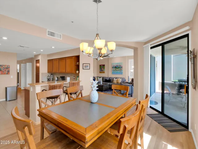 a room with stainless steel appliances a dining table and chairs